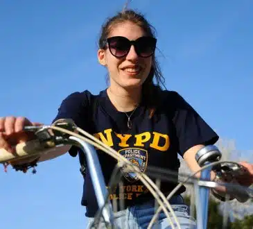 woman in black and yellow crew neck t-shirt riding bicycle during daytime