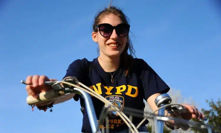 woman in black and yellow crew neck t-shirt riding bicycle during daytime