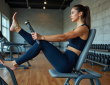 Femme sportive utilisant une machine de leg press dans une salle moderne
