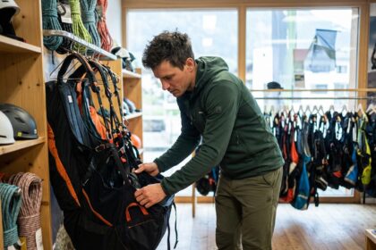 Homme examinant un harnais de parapente en boutique